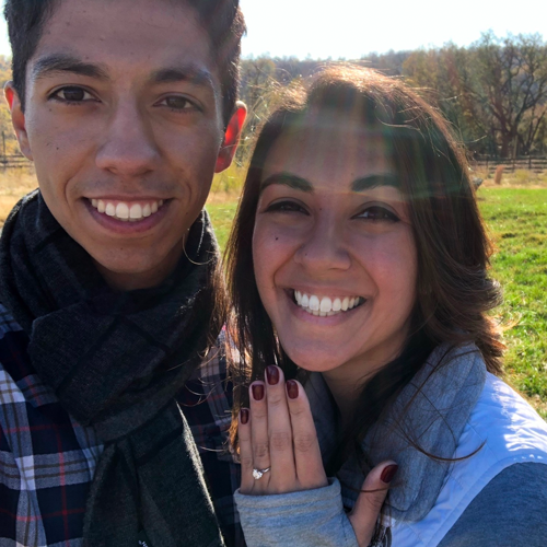 Fall Proposal Ideas: a newly-engaged couple smiles against a background of autumn foliage.