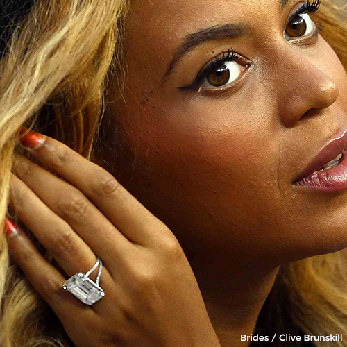 Beyoncé brushing back her hair while showing off her sparkling diamond engagement ring. 
