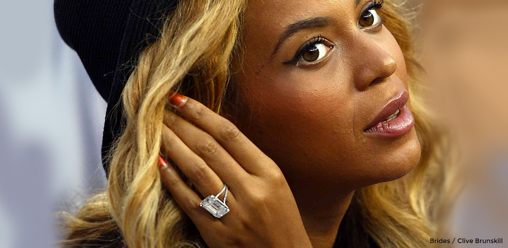 Beyoncé brushing back her hair while showing off her sparkling diamond engagement ring. 