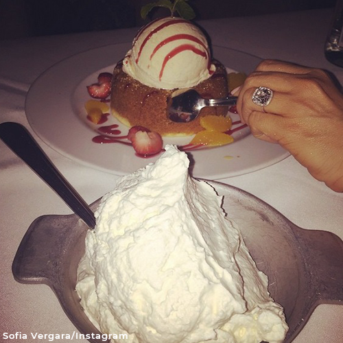 Sofia eating a piece of cake while showing off her engagement ring. 