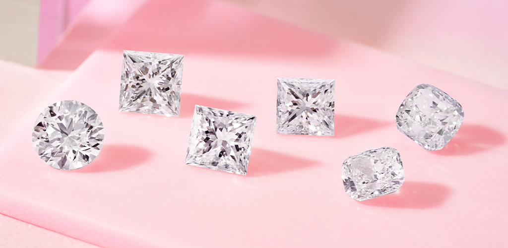 fancy shaped diamonds sitting on a pink surface 