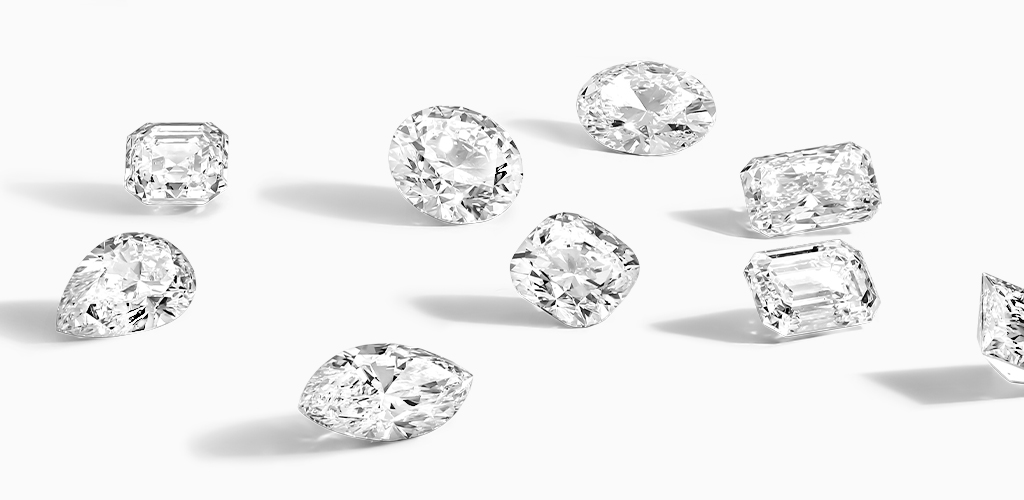A variety of loose fancy-shaped diamonds on a white surface 