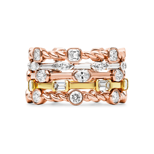 A stacked piled of different gold and diamond stackable rings 