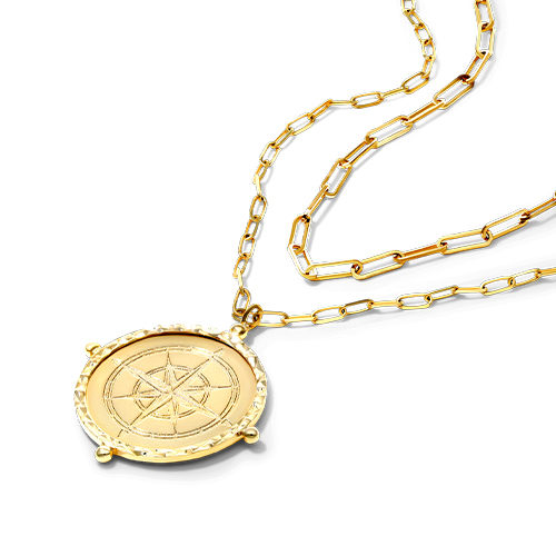 A yellow gold compass medallion paired with a paperclip chain 
