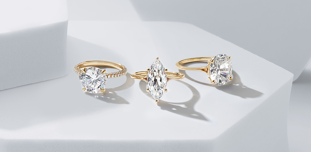 Three yellow gold diamond engagement rings with different diamond center stone shapes