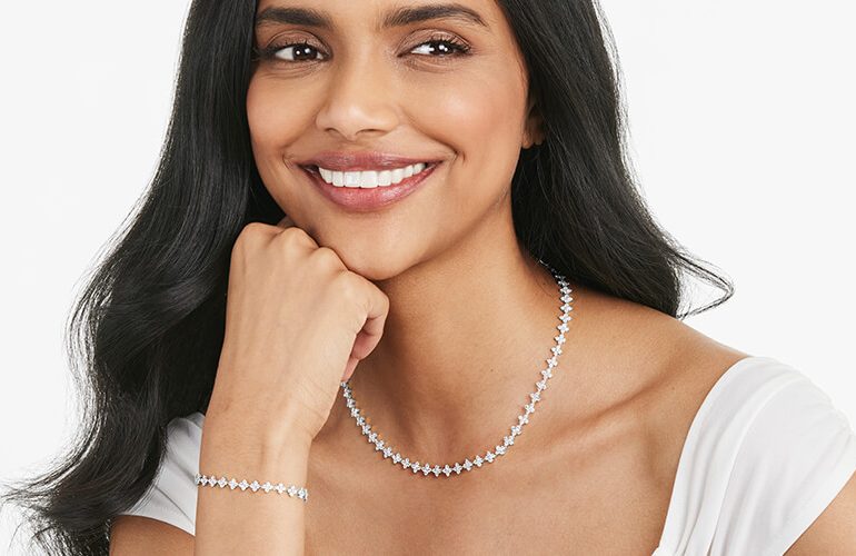 A happy woman wearing a variety of diamond jewelry