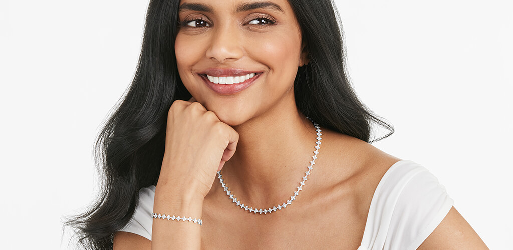 A happy woman wearing a variety of diamond jewelry