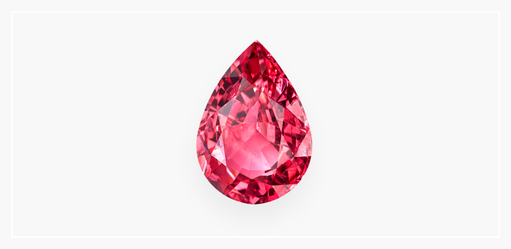 Pear-shaped pink spinel gemstone against a white backdrop. This August birthstone is featured with a faceted cut.