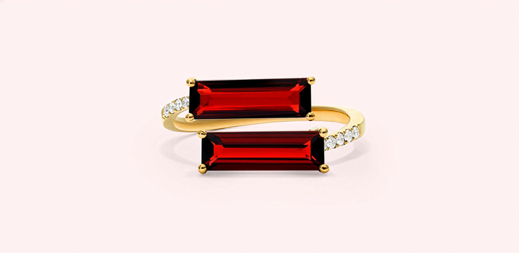 Deep red baguette-cut garnets set in a curved gold ring with small accent stones, showing a bold and modern look for the January birthstone.