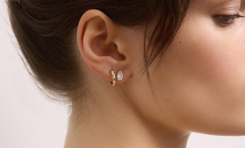 A model shows off earrings from the James Allen Bezel Expansion Collection.