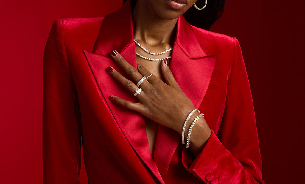 A model shows a close-up of diamond rings and tennis bracelets paired with a red blazer for James Allen Valentine’s Day collection.