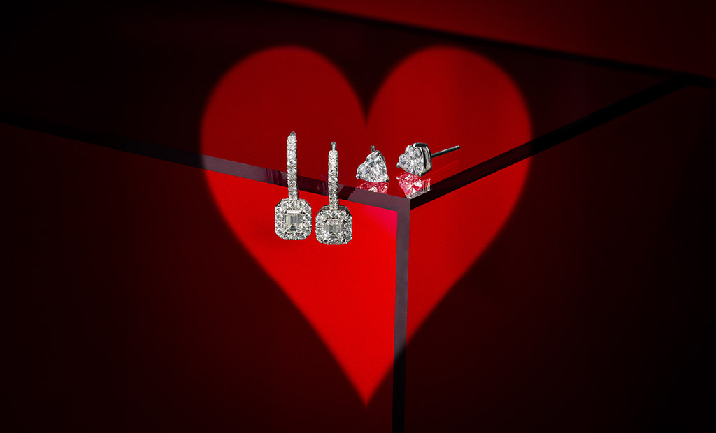 Diamond stud and drop earrings displayed against a red heart backdrop for James Allen Valentine’s Day product launch.